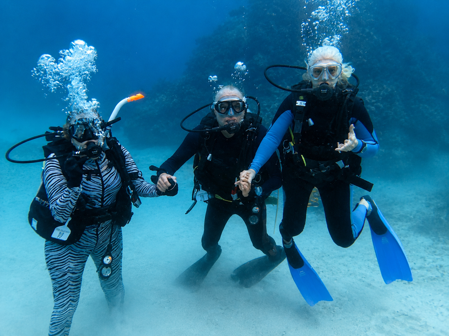 Three scuba divers enjoying a group dive trip